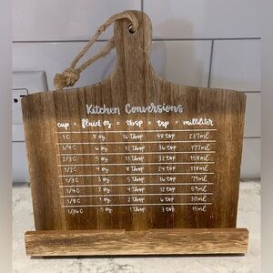 Wooden cookbook holder stand with a kitchen measurement conversion chart.